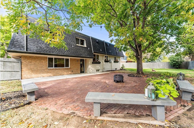 back of house with a patio and a fire pit