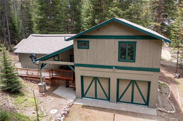 446 Blue River Rd, Breckenridge, CO 80424 - view of front of house featuring a forest view, a deck, and an attached garage
