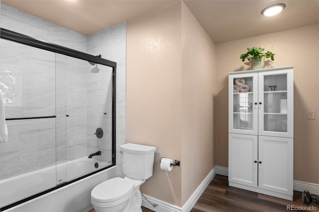 6530 Ridgeview Dr, Morrison, CO 80465 - full bath featuring wood finished floors, combined bath / shower with glass door, toilet, and baseboards