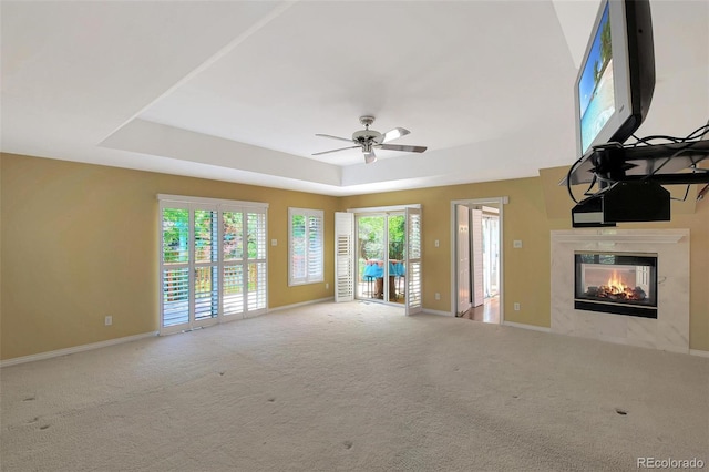 6684 E Bates Ave, Denver, CO 80224 - unfurnished living room featuring a tray ceiling, a high end fireplace, carpet, and a ceiling fan