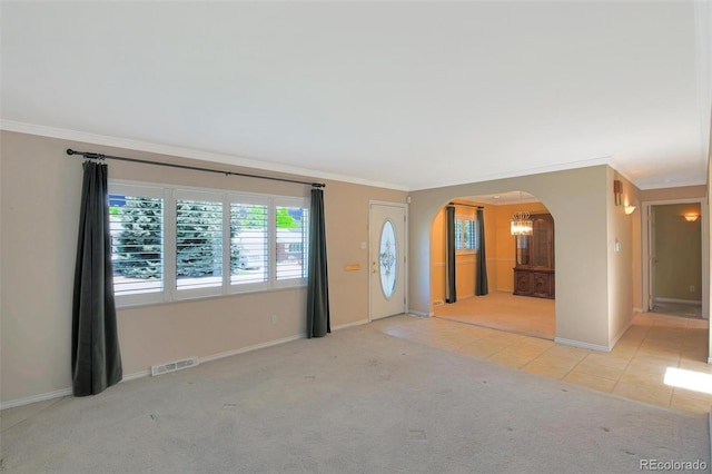 6684 E Bates Ave, Denver, CO 80224 - unfurnished living room with arched walkways, carpet, ornamental molding, plenty of natural light, and tile patterned flooring