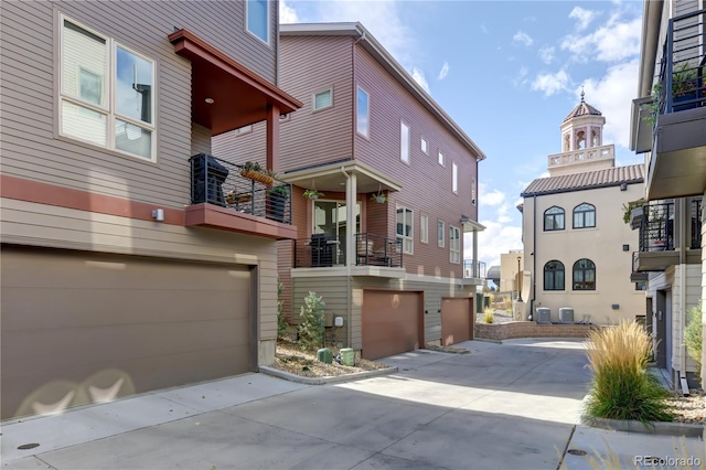 exterior space with central AC unit and a garage