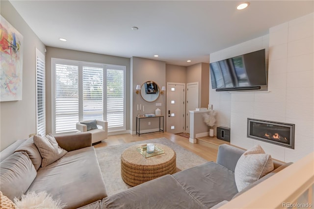 living room featuring light hardwood / wood-style floors and a tile fireplace