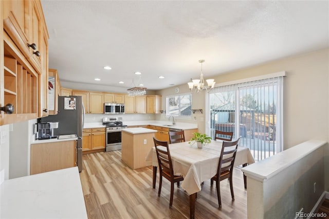 dining area with a notable chandelier, light hardwood / wood-style flooring, and sink