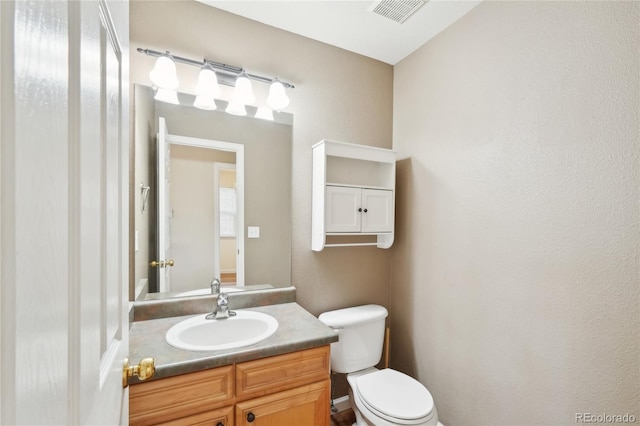 bathroom featuring toilet and vanity