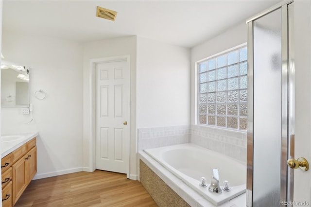 bathroom featuring vanity, hardwood / wood-style flooring, and independent shower and bath