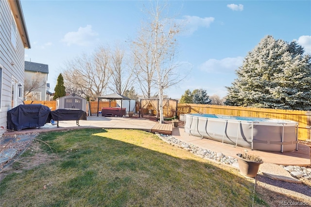 view of yard featuring a gazebo, a swimming pool with hot tub, and a shed