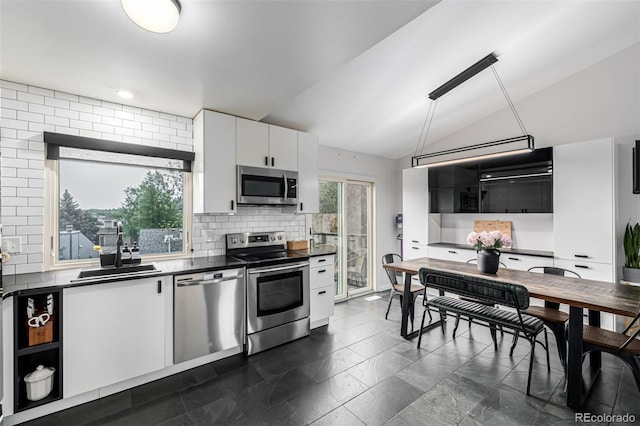 19661 E Girard Ave, Aurora, CO 80013 - kitchen featuring appliances with stainless steel finishes, a sink, dark countertops, lofted ceiling, and tasteful backsplash