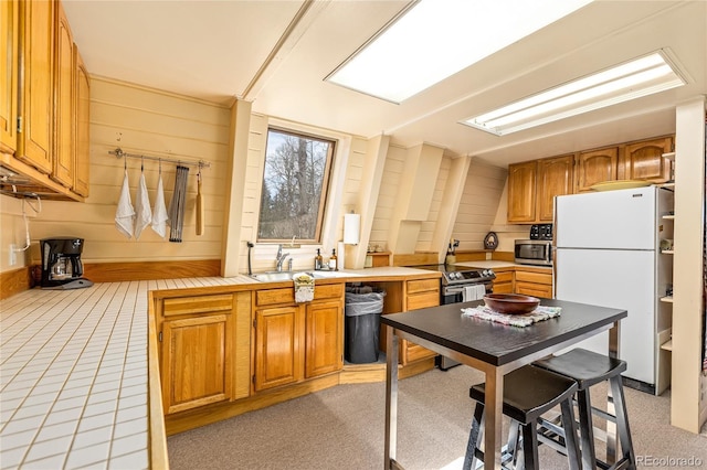 771 Spruce Rd, Cimarron, CO 81220 - kitchen featuring stainless steel appliances, wood walls, and brown cabinets