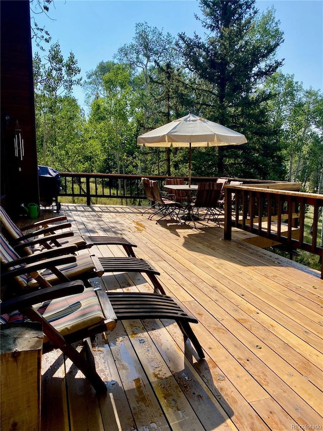 771 Spruce Rd, Cimarron, CO 81220 - wooden deck featuring outdoor dining space and view of scattered trees