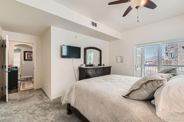 bedroom with visible vents, arched walkways, access to exterior, light carpet, and multiple windows