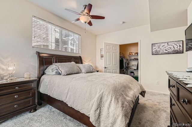 bedroom featuring a walk in closet, lofted ceiling, a closet, carpet flooring, and baseboards