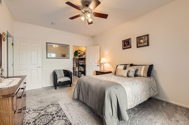 bedroom with light carpet, a closet, a walk in closet, and a ceiling fan