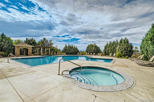 community pool with a community hot tub and a patio area