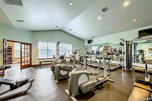 workout area with visible vents, a textured ceiling, baseboards, and vaulted ceiling