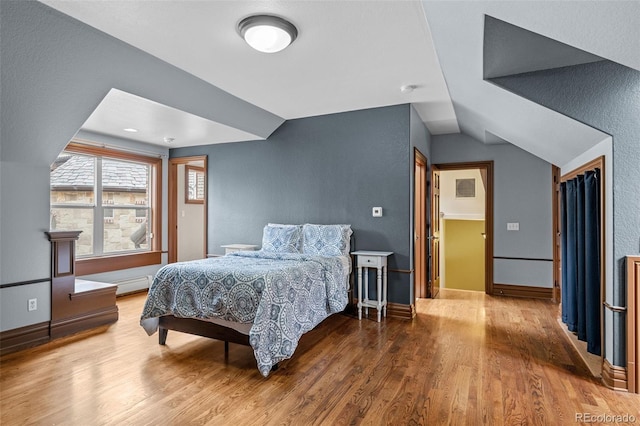 bedroom with vaulted ceiling and hardwood / wood-style floors