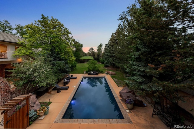 pool at dusk featuring a patio area