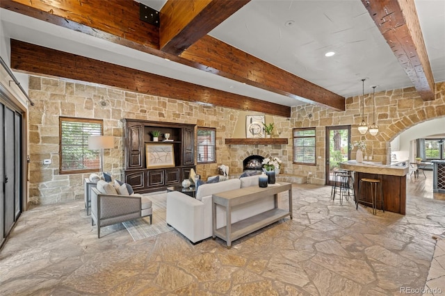 living room with beamed ceiling and a fireplace