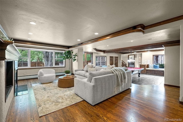 living room featuring a baseboard heating unit, a textured ceiling, and hardwood / wood-style flooring