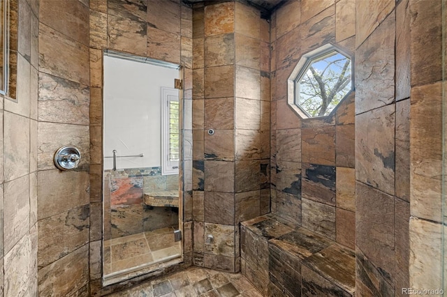 full bathroom featuring stone finish floor and a tile shower