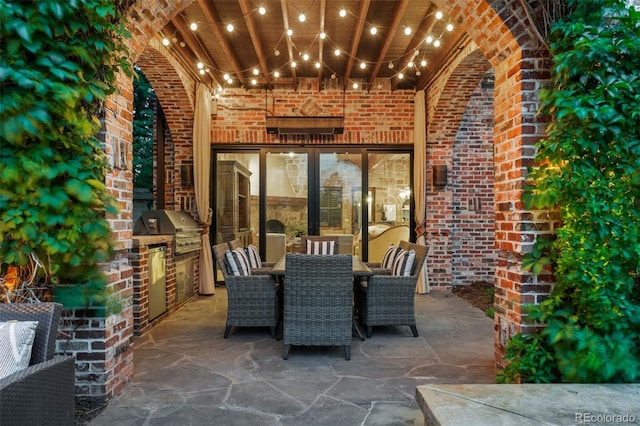 view of patio with a grill, outdoor dining area, and exterior kitchen