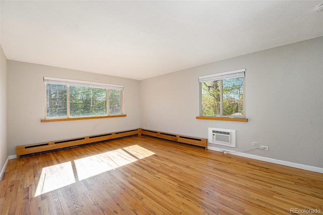 1144 N Ogden St Unit 304, Denver, CO 80218 - empty room featuring healthy amount of natural light, wood finished floors, a baseboard radiator, and a wall mounted AC