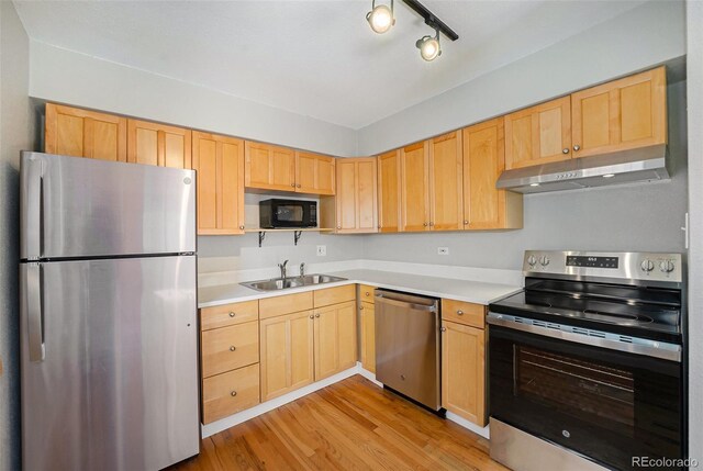 1144 N Ogden St Unit 304, Denver, CO 80218 - kitchen with stainless steel appliances, under cabinet range hood, light brown cabinetry, and a sink