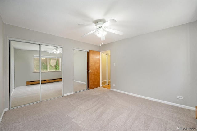 1144 N Ogden St Unit 304, Denver, CO 80218 - unfurnished bedroom featuring a baseboard heating unit, multiple closets, carpet, and baseboards