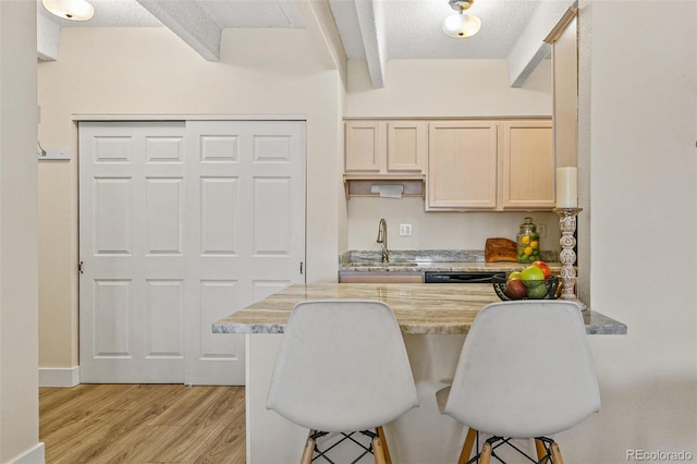 kitchen featuring a breakfast bar, a textured ceiling, and sink