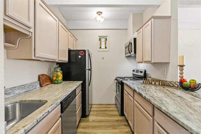 kitchen featuring light brown cabinets, light hardwood / wood-style flooring, and appliances with stainless steel finishes