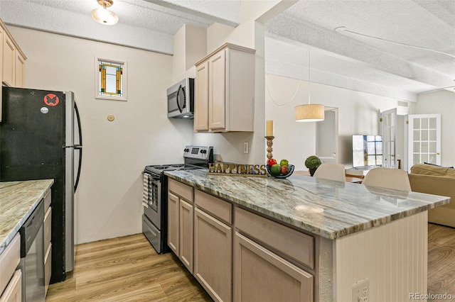 kitchen with light wood-type flooring, light brown cabinetry, a textured ceiling, and appliances with stainless steel finishes