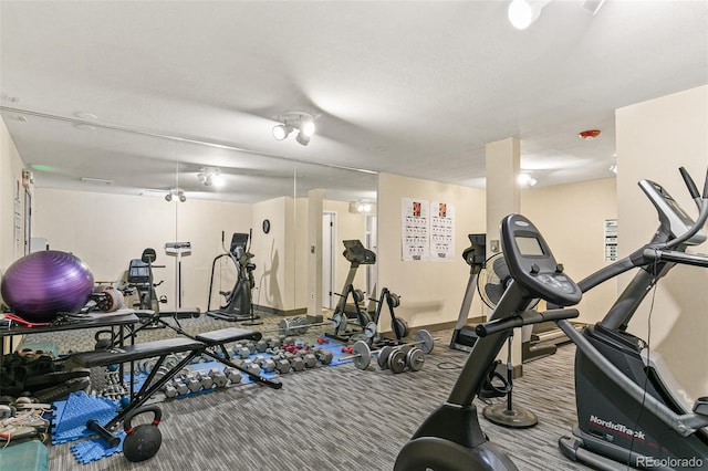 workout area with carpet flooring and a textured ceiling