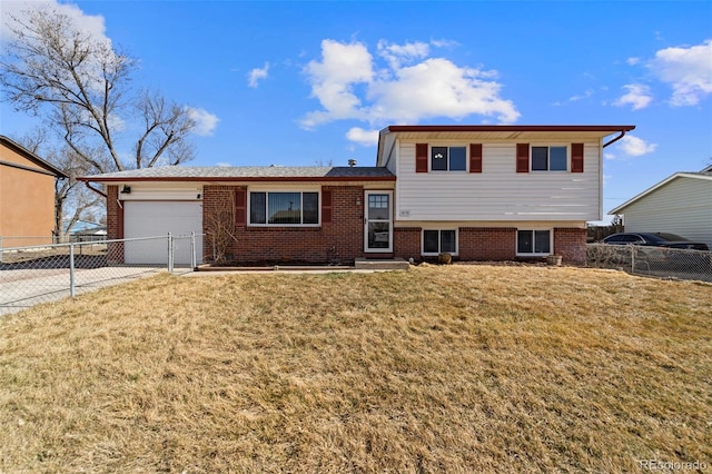 tri-level home with a garage, brick siding, concrete driveway, and a front lawn