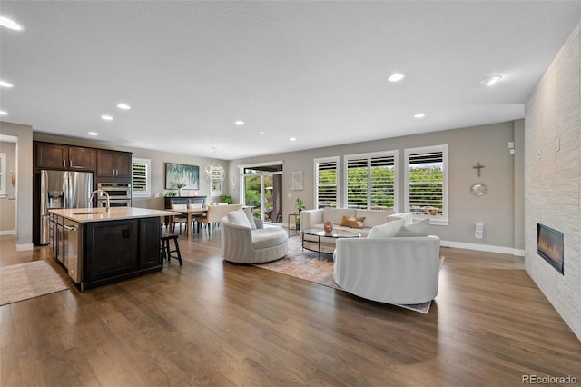 5608 Raintree Dr, Parker, CO 80134 - living room featuring dark wood-style floors, recessed lighting, baseboards, and a large fireplace