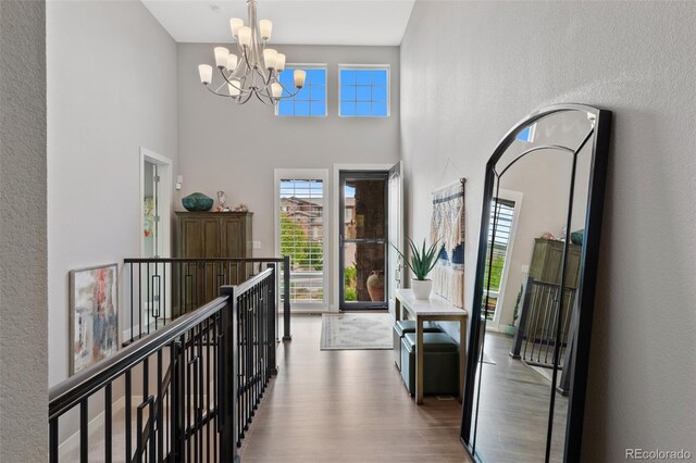 5608 Raintree Dr, Parker, CO 80134 - hall featuring wood finished floors, a chandelier, plenty of natural light, and a towering ceiling