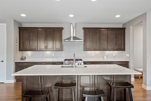 5608 Raintree Dr, Parker, CO 80134 - kitchen featuring wall chimney exhaust hood, a sink, dark wood finished floors, dark brown cabinets, and recessed lighting