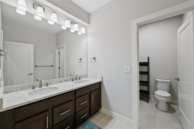 5608 Raintree Dr, Parker, CO 80134 - bathroom featuring double vanity, toilet, baseboards, and tile patterned flooring