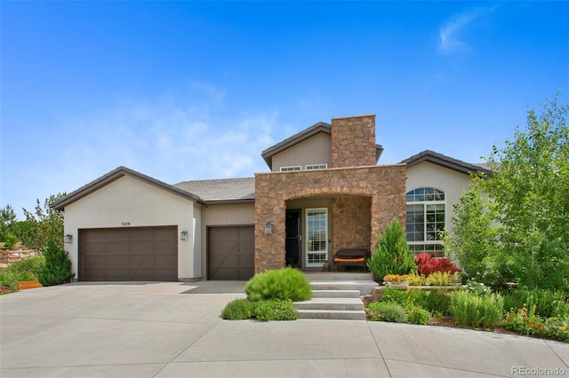 5608 Raintree Dr, Parker, CO 80134 - view of front facade with a garage, driveway, stucco siding, and stone siding