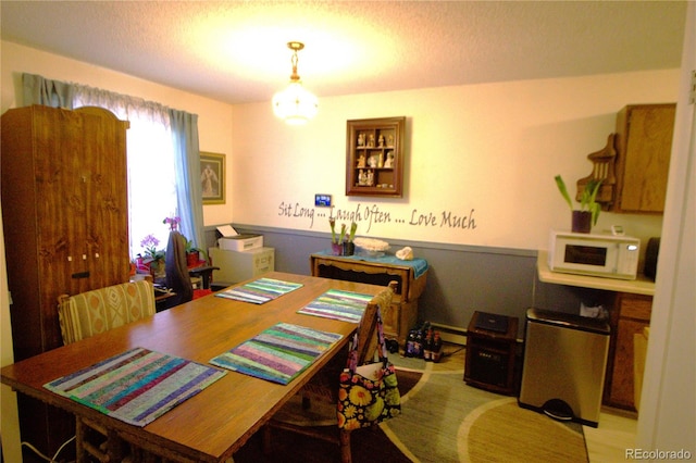 dining room featuring a textured ceiling and a baseboard radiator