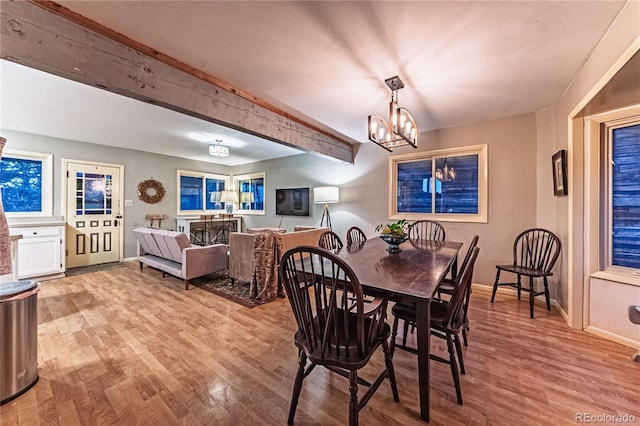 dining area featuring baseboards, a chandelier, beamed ceiling, and wood finished floors