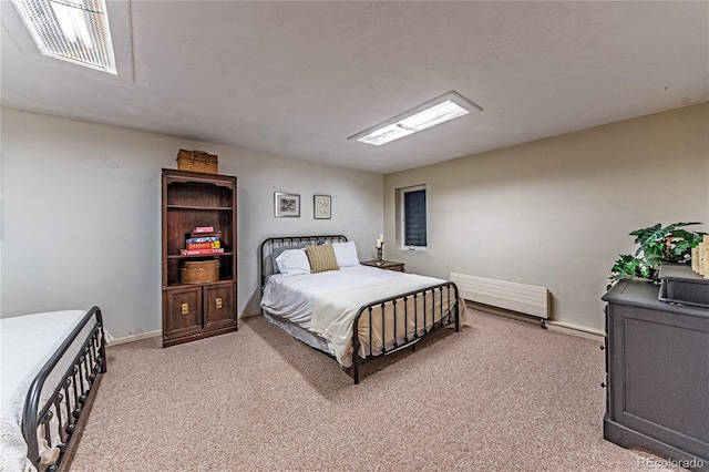 bedroom featuring light carpet, radiator heating unit, visible vents, and baseboards