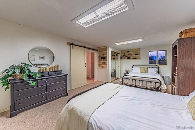 bedroom featuring carpet floors, a barn door, visible vents, and baseboards