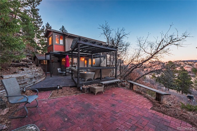 back of property at dusk with a patio and a pergola