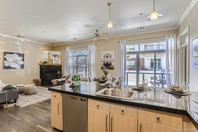 kitchen with light brown cabinetry, open floor plan, dark wood finished floors, a glass covered fireplace, and a sink