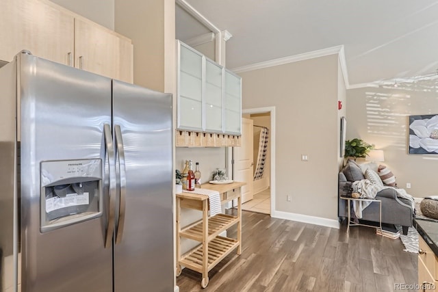 kitchen featuring modern cabinets, stainless steel fridge, crown molding, baseboards, and dark wood-style flooring