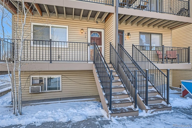 snow covered property entrance with covered porch