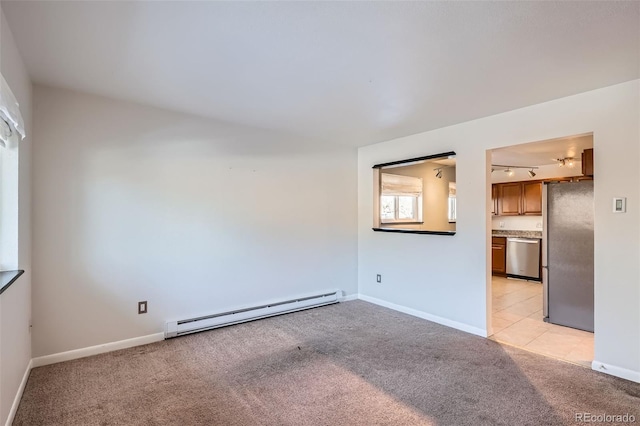 empty room with light carpet, rail lighting, and a baseboard radiator