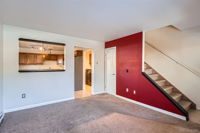 unfurnished living room featuring light colored carpet and a baseboard heating unit