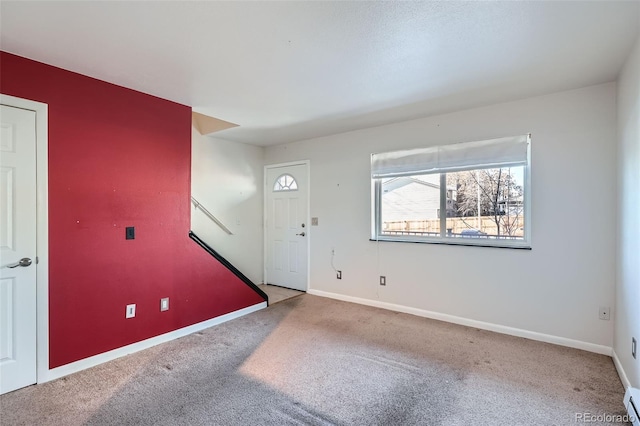 carpeted foyer with a baseboard heating unit