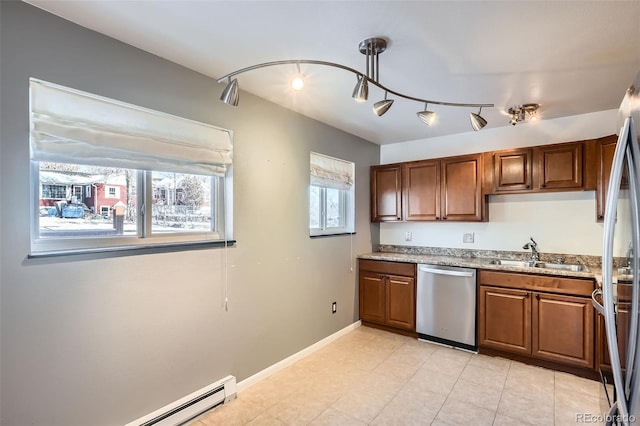 kitchen with light stone countertops, sink, a baseboard heating unit, and appliances with stainless steel finishes